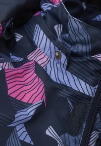 Marinblått tyg med rosa och ljuslila abstrakta mönster. Utrustad med en silverfärgad tryckknapp och en svart kardborreflik. Texturerad yta.