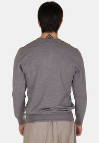 Maglione grigio realizzato in tessuto morbido con colletto rotondo e bordo a coste. Presenta maniche lunghe e una superficie liscia.