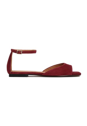 Sarkanas zamšādas plakanas sandales ar atvērtu purngalu, potītes siksniņu un zemiem papēžiem. Gluda tekstūra un minimālistisks dizains ar izgriezuma detaļu aizmugurē.