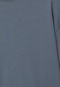 Šedé bavlněné tričko s hladkou texturou, kulatým výstřihem a krátkými rukávy. Jednotná barva bez viditelných vzorů nebo akcentů.