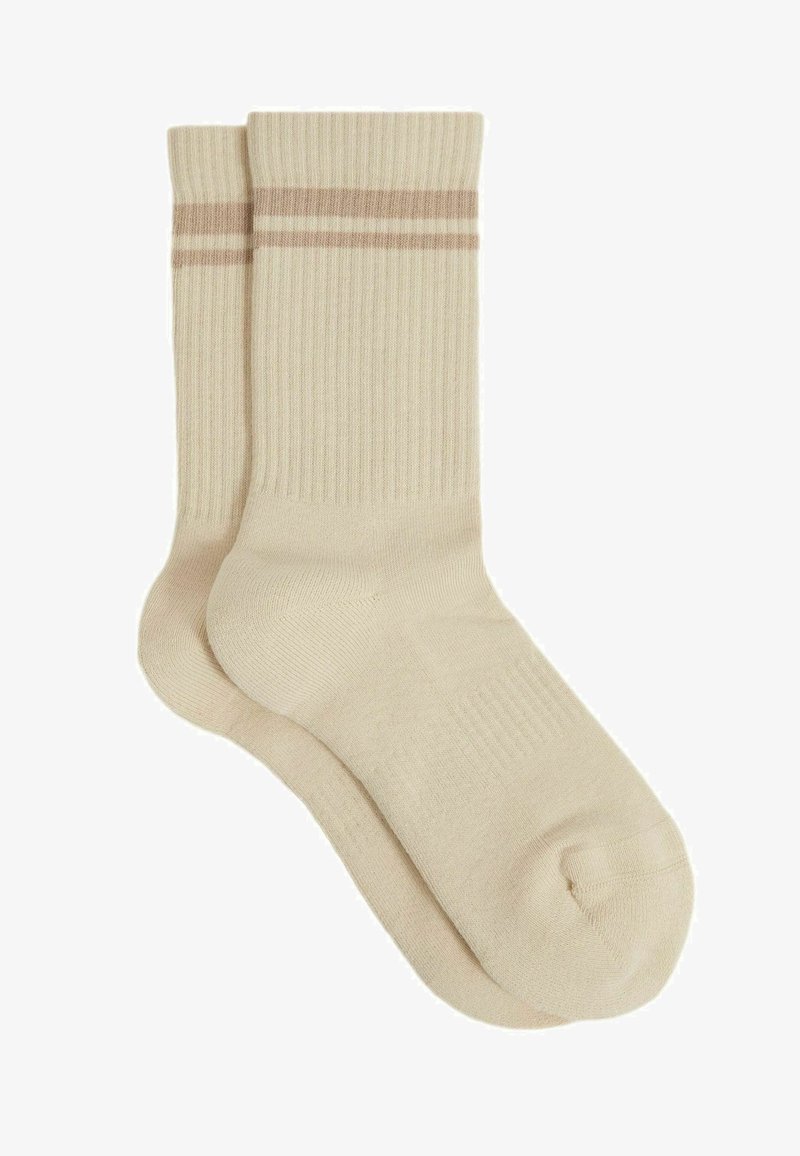 Beige bomuldsokker med ribbet tekstur, prydet med to vandrette beige striber øverst. Standard længde med forstærket hæl og tå.