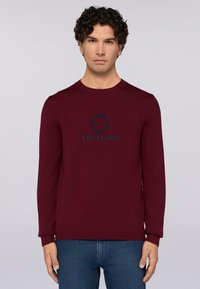 Burgundské pletené svetr s kulatým výst�řihem, vyšívaným logem "TRUSSARDI" v námořnické modři, rib na manžetách a spodním lemu a těsným střihem.