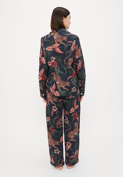 Conjunto de pijama azul-marinho feito de tecido suave com estampado de flores e de leopardo. Apresenta uma camisa de botão e calças largas com mangas longas.