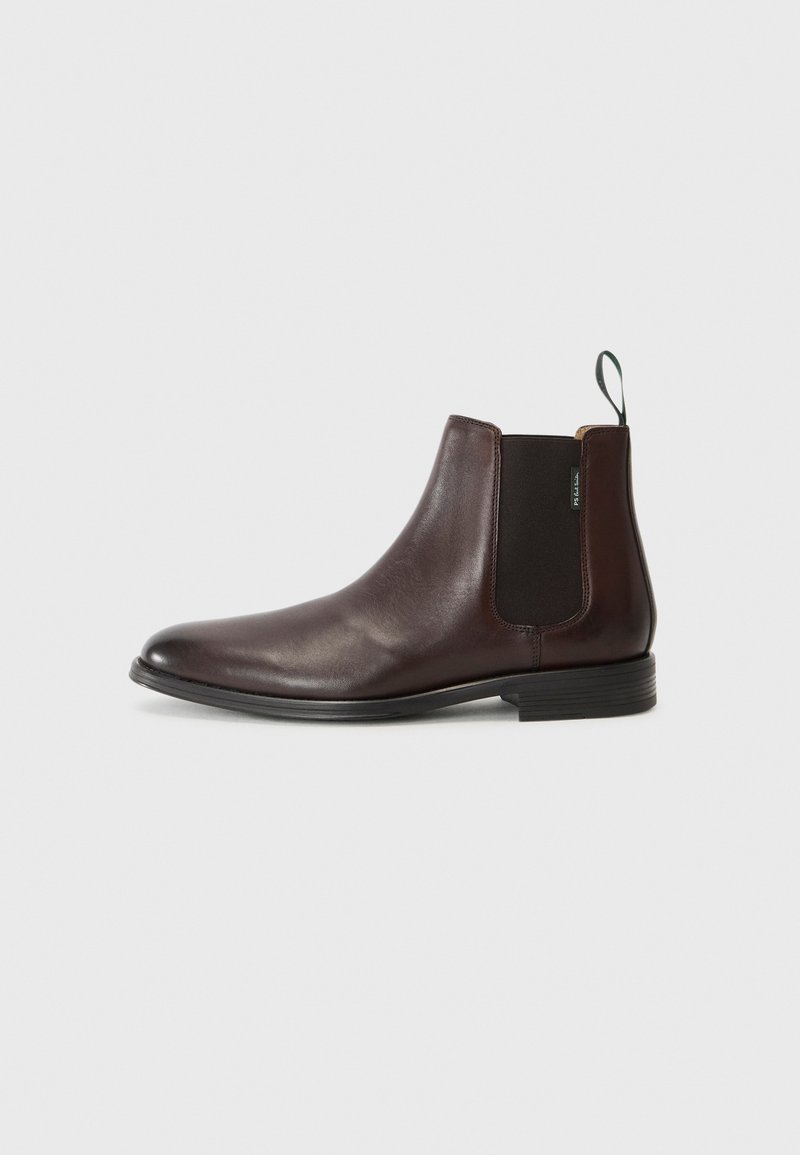 Bottines en cuir marron avec des panneaux élastiques sur les côtés et une languette. Texture lisse, bout rond et un petit talon empilé.