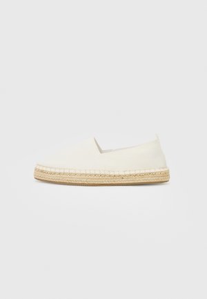Sapatilha de lona branca com sola de corda de juta, bico arredondado e laterais elásticas para fácil calçar. Design plano, estilo minimalista.