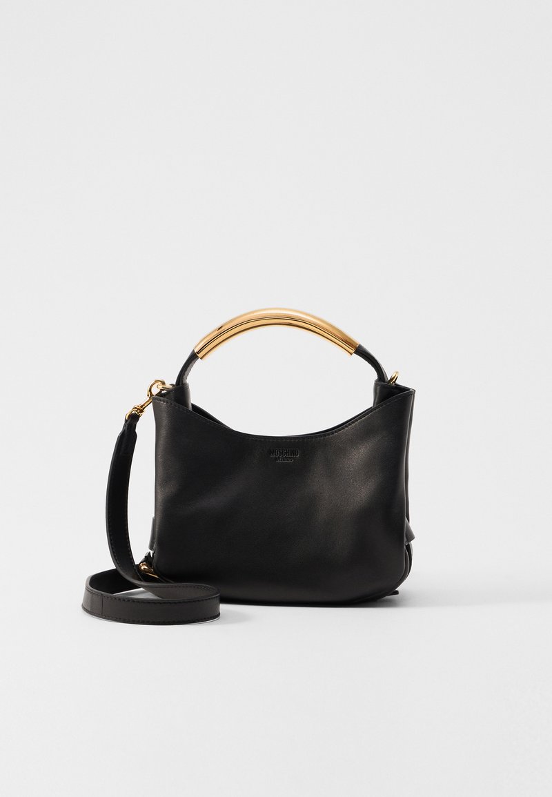 Black leather handbag with a curved golden handle and detachable shoulder strap. Smooth texture and minimalist design with brand logo visible.