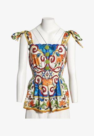 Blusa sin mangas con estampado floral, tirantes anudados, botones verdes al frente, cintura fruncida y patrones vibrantes en naranja, azul, verde y rojo sobre tela blanca.