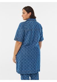 Blå denimskjortklänning med korta ärmar, med fiskbensmönster och krage, som når mitt på låret, med avslappnad passform och sömnadsdetaljer.