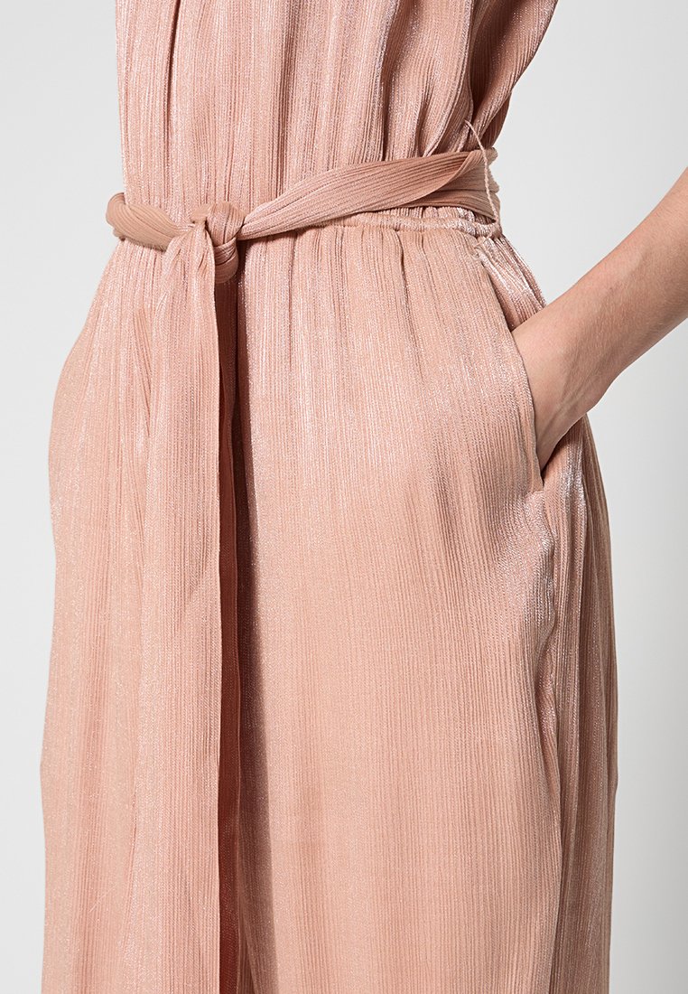 Blush-pink, plissierter Jumpsuit mit einem selbstbindenden Taillengürtel, der eine glatte, glänzende Textur und Seitentaschen für zusätzlichen Komfort bietet.