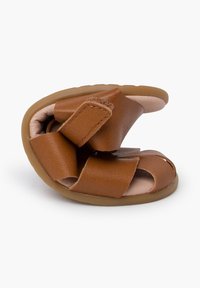 Rudos odinės šlepetės su apvalia forma, Velcro diržais ir minkštu vidiniu pamušalu. Padas yra lengvas ir lanksčius.
