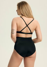 Czarny stanik i wysoki dół bikini, z regulowanymi ramiączkami i zapięciem na hak. Gładka faktura o minimalistycznym designie.