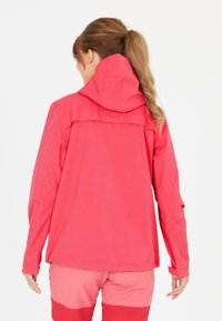 Vattentålig rosa jacka med huva, lättviktsdesign, långa ärmar och en avslappnad passform. Har sömnadsdetaljer längs sömmarna.
