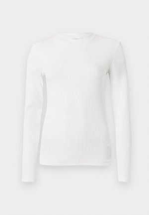 Dlouhý rukáv bílého žebrového topu s kulatým výstřihem a přiléhavým střihem. Hladká textura, minimální detaily a pružná látka.