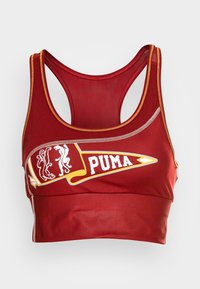 Czerony stanik sportowy wykonany z gładkiego materiału z plecakiem typu racerback. Posiada logo PUMA oraz graficzne akcenty w kolorze żółtym i białym.