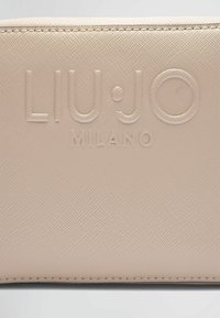 Beige tekstureret pung med præget "LIU•JO" og "MILANO" logo. Glat materiale med synlige sømme og en blød overflade.