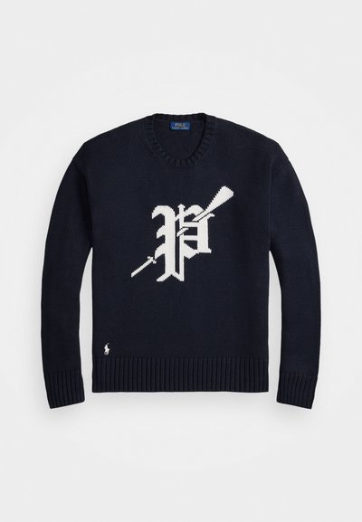 Mornarsko moder pleteni pulover z belim gotskim stilom "P" in prekrižanima polo palicama spredaj, rebrastimi manšetami in robom.