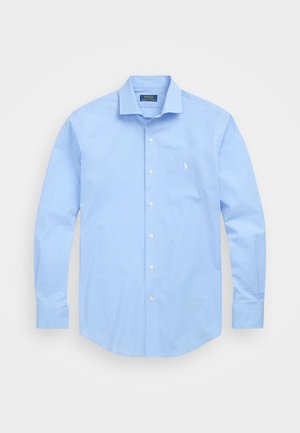 Svetlo modra srajca s kratkimi rokavi in majhnim, subtilnim vzorcem. Ima klasičen ovratnik, dolge rokave in en sam logotip na prsih.