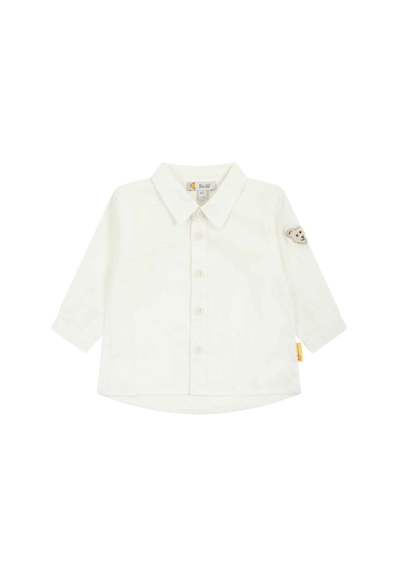 Camicia bianca a maniche lunghe con colletto, apertura con bottoni e ricamo di un orso sulla manica sinistra. Materiale in cotone morbido, vestibilità casual.