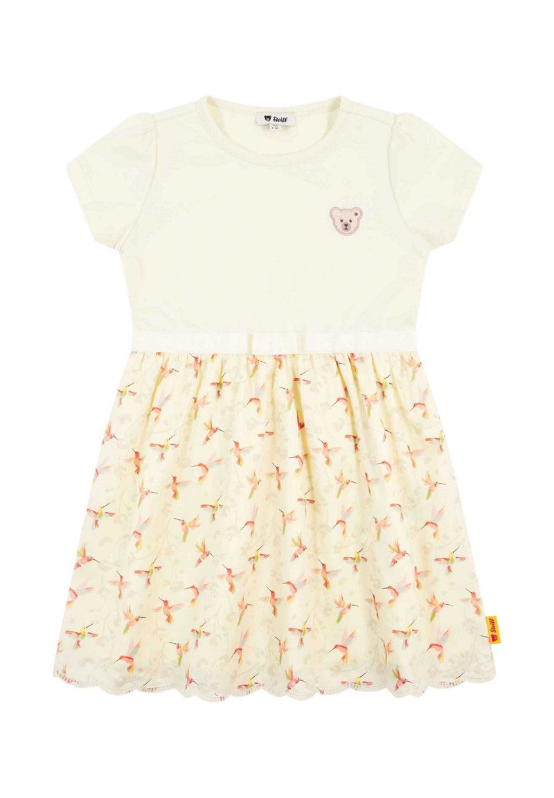 Vestido de manga corta con parte superior crema y falda de un suave amarillo con estampado floral; presenta una aplicación de oso en el pecho y un dobladillo con forma de concha.