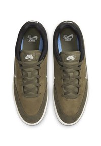 Nike SB apavi, olīvu zaļš zamšs un siets uz Augšdaļas, melna iekšējā odere, balts logos, saistāma dizains un teksturēta gumijas zole.