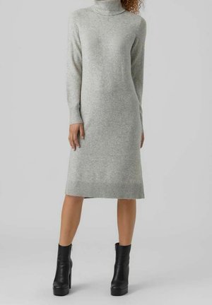Graues Strick-Turtleneck-Kleid mit langen Ärmeln, gerippten Bündchen und Saum, mittellanges Design; kombiniert mit schwarzen, knöchelhohen Stiefeln mit Absatz.