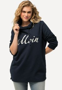 Námořnická modrá mikina s rolákem a šňůrkou. Na přední straně bílý nápis "Allrin". Dlouhé rukávy s ohrnutými manžetami, mírně delší zadní lem.