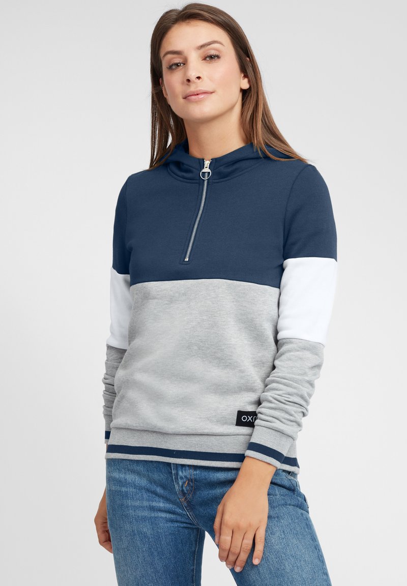 Felpa con cappuccio blu navy e grigia con design a mezza zip, presenta dettagli bianchi sulle maniche e un corpo grigio testurizzato. Include polsini e orlo a coste.