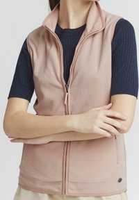 Ljusrosa fleeceväst med dragkedja fram, ståkrage, sidofickor och ribbade navy ärmar. Mjuk textur, avslappnad design.