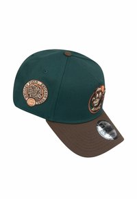 Grüne und braune verstellbare Baseballmütze mit gestickten Patches auf der Vorderseite, die Natur- und Charakterdesigns zeigen, aus Baumwollmaterial gefertigt.