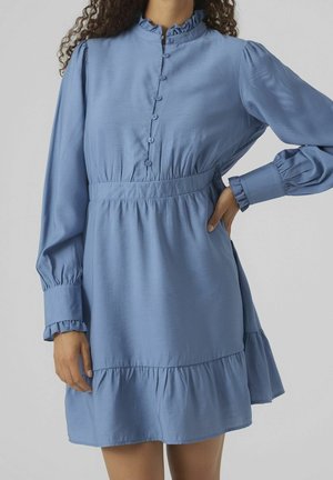 Robe bleu clair en tissu lisse, avec un col à volants, une fermeture à boutons sur le devant, de longues manches bouffantes et une jupe à volants.