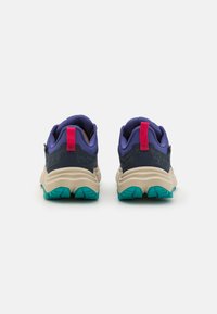 Adidași de traseu cu un material superior din plasă de culoare violet, talpă intermediară bej, talpă exterioară turcoaz și o tabără de călcâi roz cu accente texturate pentru aderență.