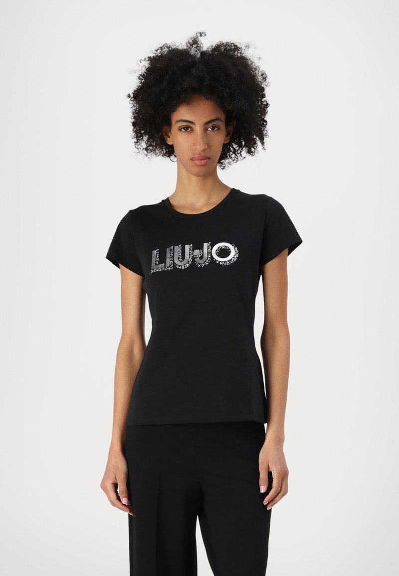Musta puuvillainen t-paita lyhyillä hihoilla, jossa on kiiltävä "LIUJO"-logo, joka on koristeltu hopea-yksityiskohdilla rinnan kohdalla.