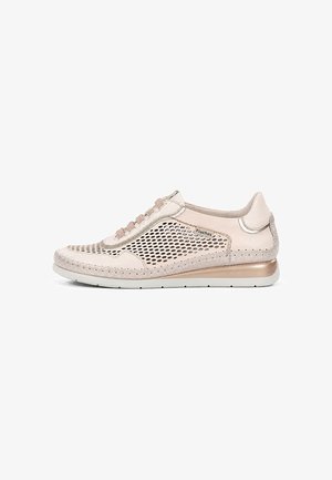 Zapatilla beige de caña baja con paneles laterales de malla, cierre de cordones en la parte frontal, suela acolchada y logo "Fluchos" en el lateral.