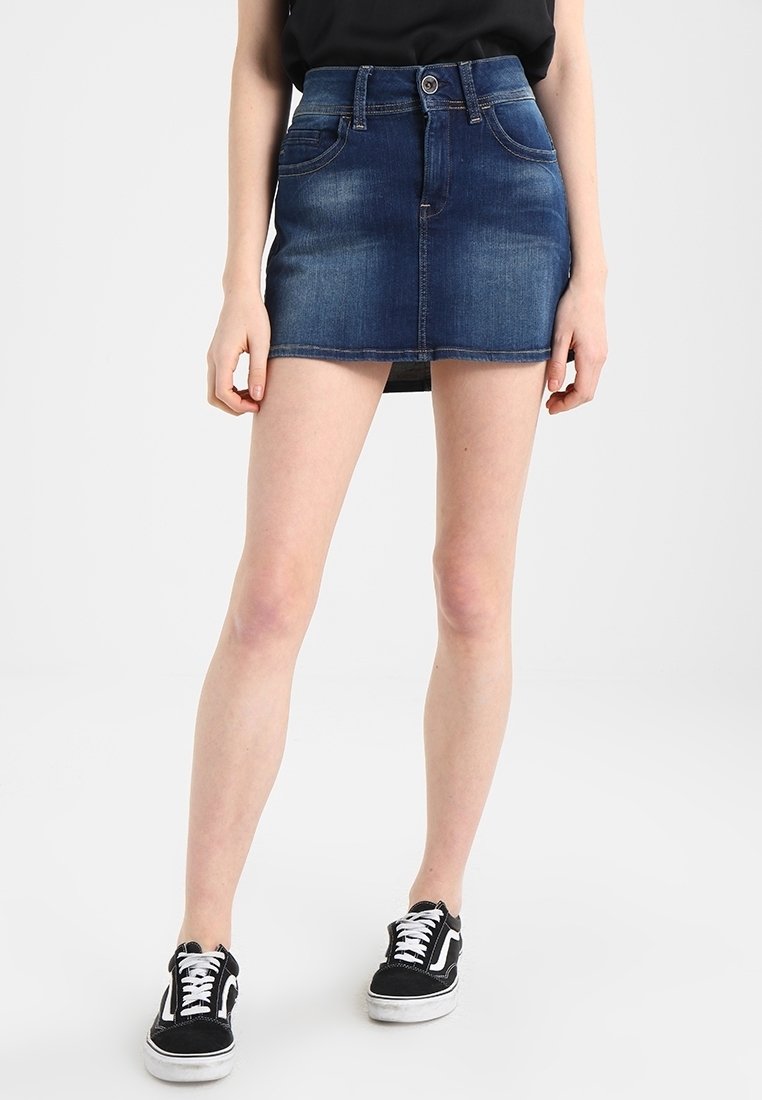 Jupe en denim courte en délavage bleu foncé, avec cinq poches, passants de ceinture et fermeture à bouton sur le devant. Texture lisse, design ajusté.