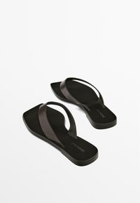 Black flip-flops with flat, wide straps. The soles are smooth with a matte finish, and the straps feature a subtle sheen.