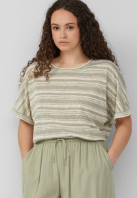 Gestreepte top met korte mouwen in lichtgroen en beige, gemaakt van een zachte, gestructureerde stof. Losse pasvorm met een ronde halslijn en opgerolde mouwen.