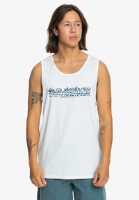 Valkoinen puuvillapaita, jossa on sininen Quiksilver-logo ja graafinen design rinnassa. Yksinkertainen, rento malli, jossa on leveät käsiaukot.
