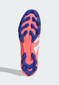 Suola di scarpa da calcio con tacchetti, caratterizzata da una base di un brillante colore rosa e picchi di trazione blu. Presenta un design aerodinamico con dettagli di texture e grip ben visibili.