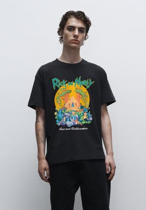 Černé bavlněné tričko s barevným potiskem "Rick a Morty" v okrouhlém designu, s kreslenými postavami a textem ve spodní části.