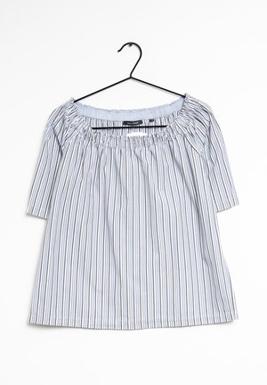 Blouse à rayures verticales bleues et blanches, épaules dénudées, avec encolure élastique et manches mi-longues sur un cintre noir, fond blanc.