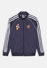 Navy blue Adidas track jacket with white stripes on sleeves, front zipper, orange Adidas logo, and colorful cartoon flower patches on left chest.