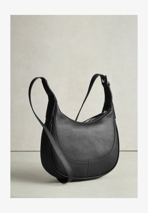 Juoda odinė petnešinė rankinė su apvalia forma, tekstūruota paviršiaus ir ilgu reguliuojamu dirželiu. Turi užtrauktuko uždarymą ir subtilias siuvimo detales.