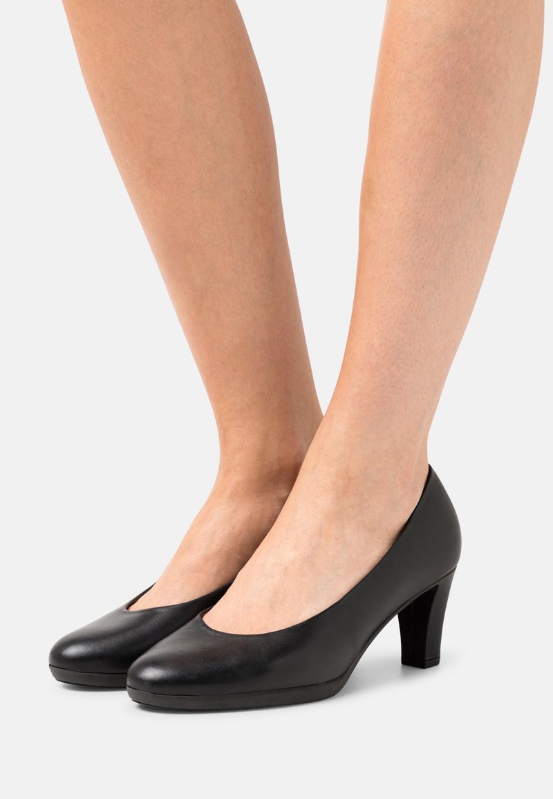 Escarpins en cuir noir à talons hauts, avec un bout arrondi et une découpe basse sur les côtés, dotés d'une finition texturée et d'un talon bloc solide.