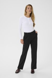 Long-sleeved white henley top with buttoned placket, paired with high-waisted black trousers that have a tailored fit and double front buttons.