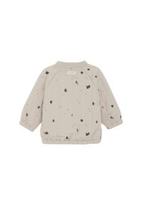 Veste rose clair avec une finition texturée, dotée d'un col rond, de poignets élastiques et de motifs éclaboussés noirs sur l'ensemble.