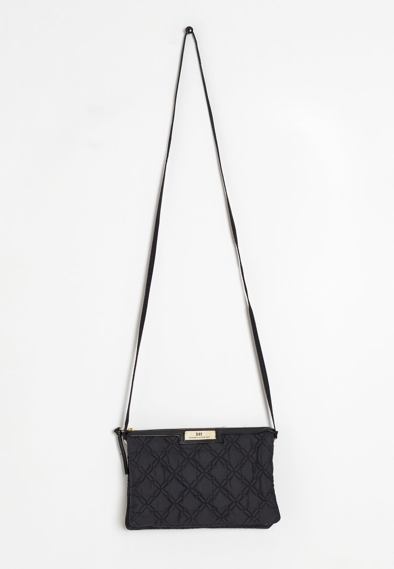 Schwarze, gesteppte Crossbody-Tasche mit strukturiertem Muster, Reißverschluss und metallischem Markenplättchen. Verstellbarer Riemen enthalten.