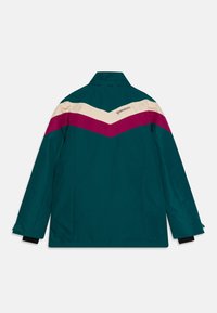 Tealjacka med krämfärgad och magentafärgad chevronmönster på axlarna. Har ståkrage och långa ärmar. Logotyp placerad på ryggen.
