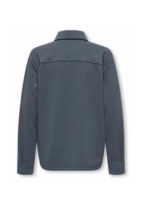 Pelēkā garo piedurknu polo krekls, izgatavots no tekstūru auduma. Tam ir apkakle un piedurkņu maliņas, ar gludu apdari un minimālu dizainu.