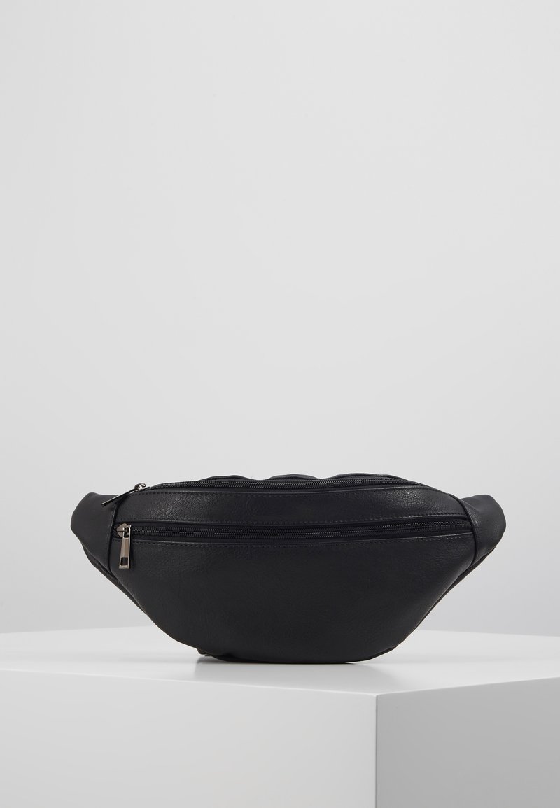 Sac en simili cuir noir de forme arrondie, doté d'un compartiment zippé et d'une surface texturée. Design minimaliste sans embellissements supplémentaires.