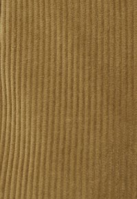 Telacorduroy marrón con nervios verticales, textura suave y un tono cálido, adecuado para tapicería o prendas de vestir.